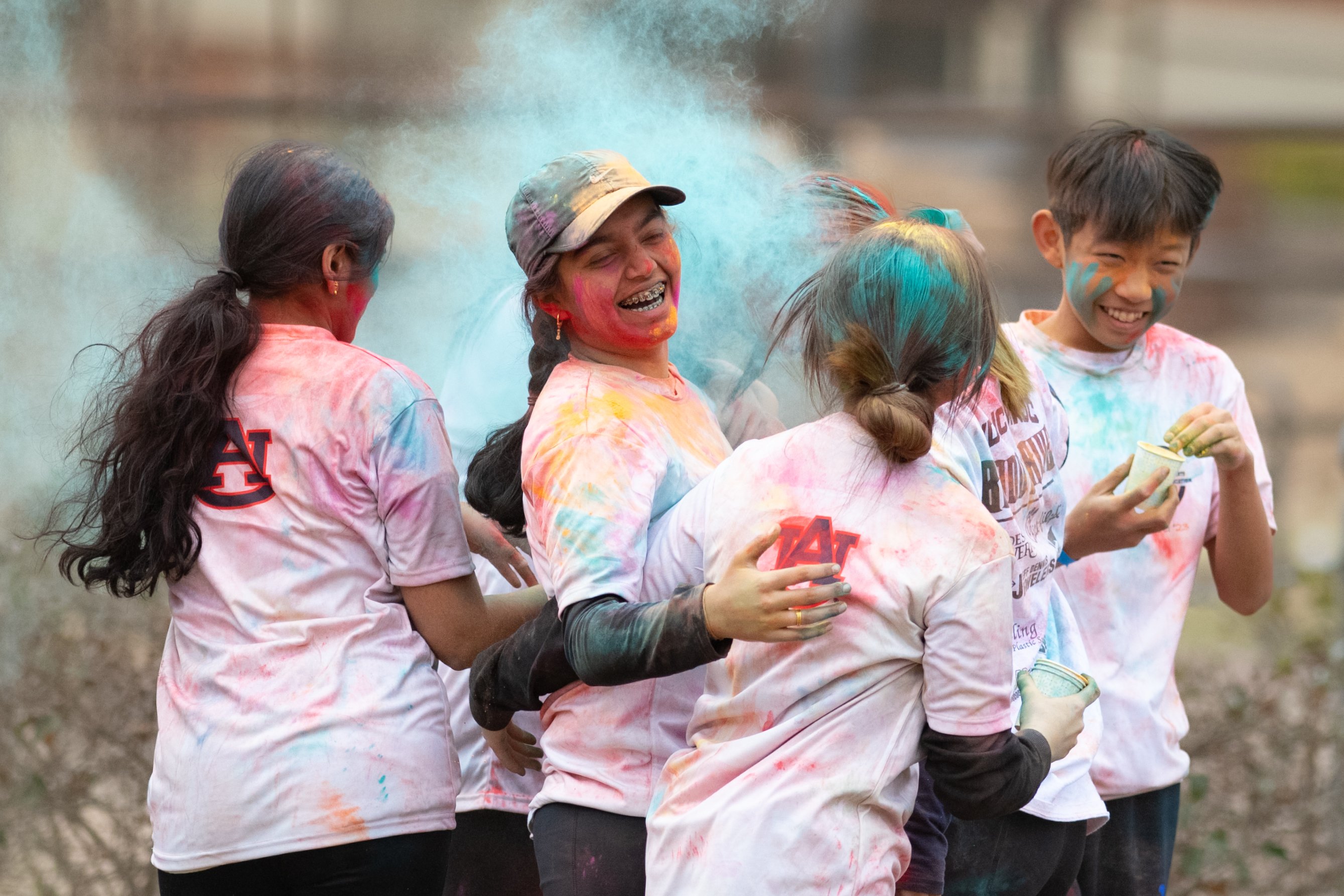 Auburn's international students celebrating holi in a cloud of multicolored paint