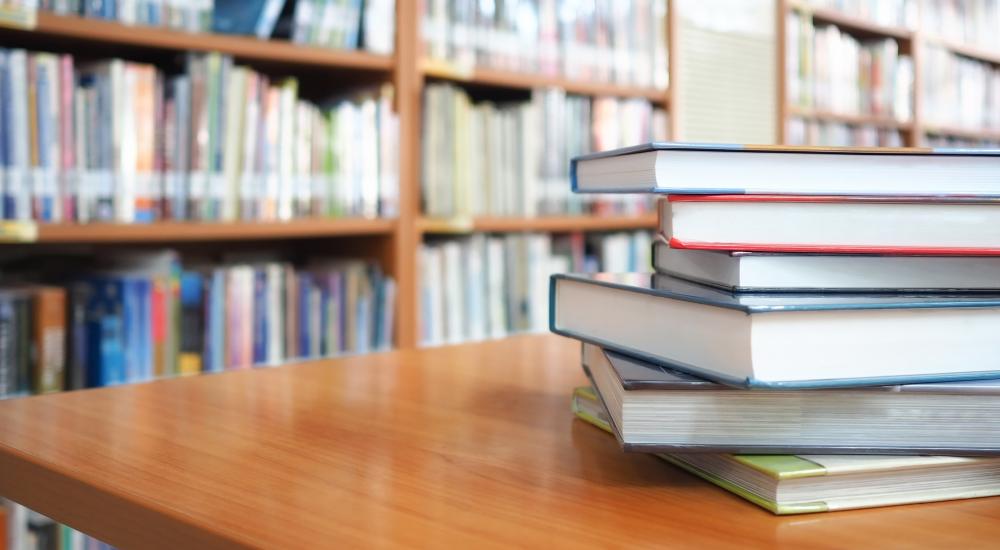 stack of books on a table in a library