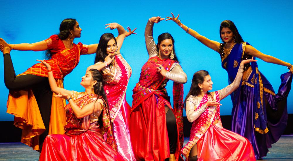 Indian students performing a dance on a stage