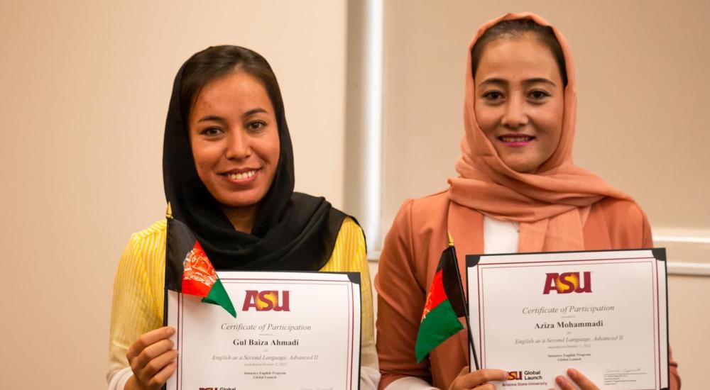 Two women hold certificates