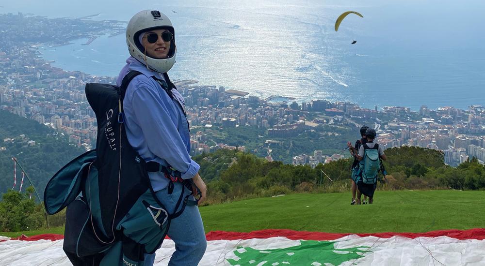 Photo of a woman on top of a hill wearing a helmet