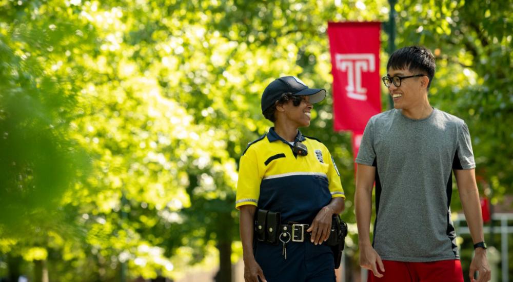 International student and police officer walking on campus