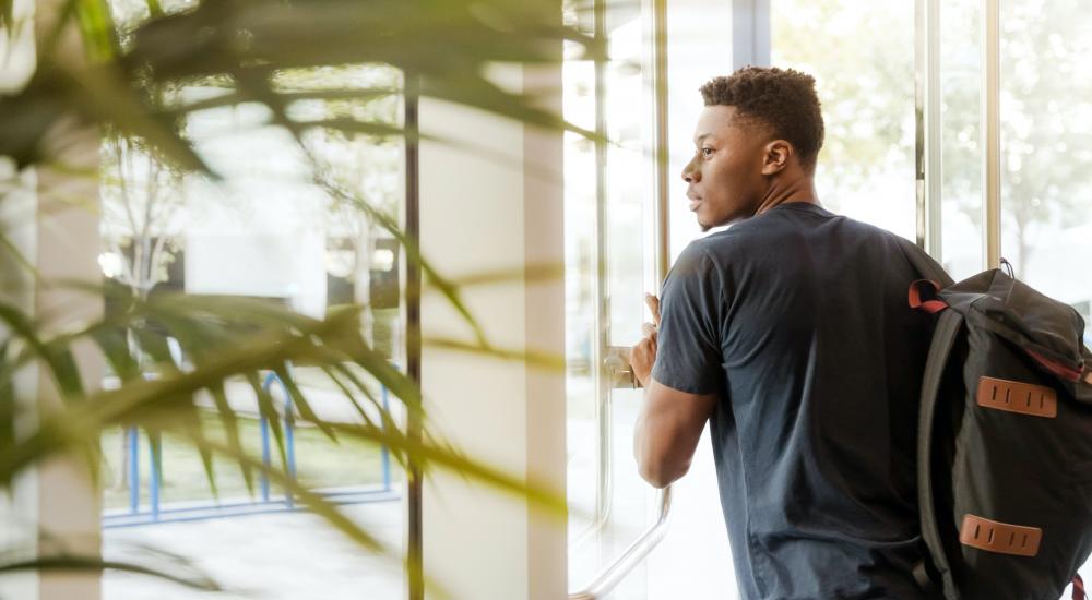 Photo of a student walking out of a building