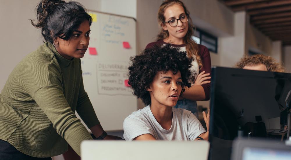 Group of coworkers looking at a computer screen