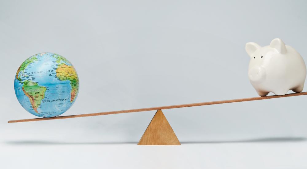 globe and piggy bank balancing