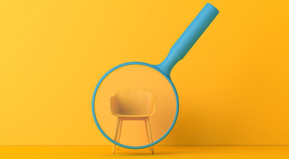 Blue magnifying glass over a yellow chair