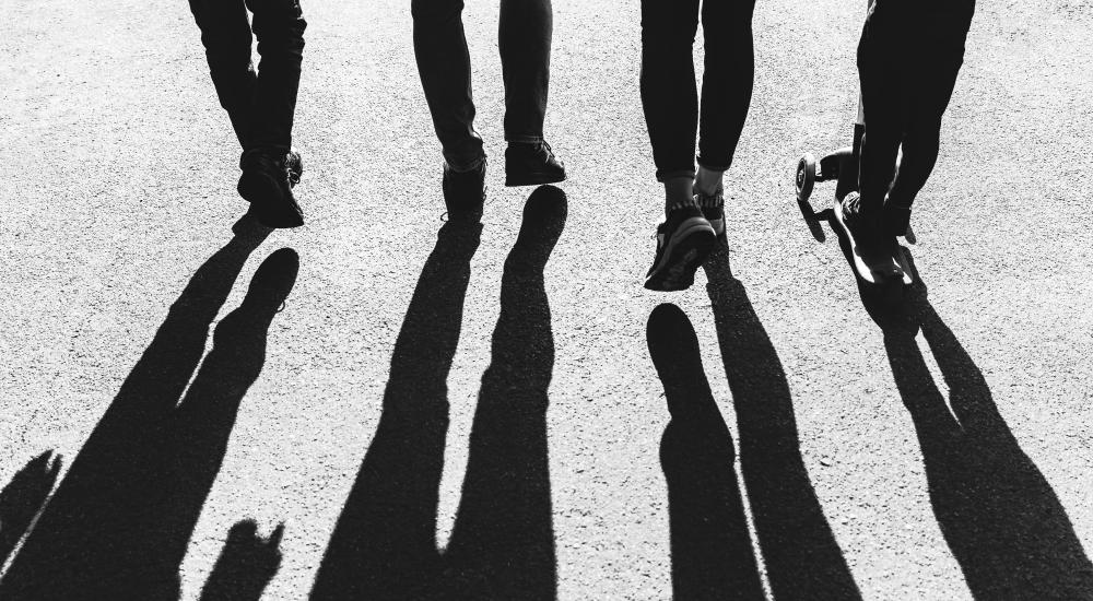 Shadows of four people walking