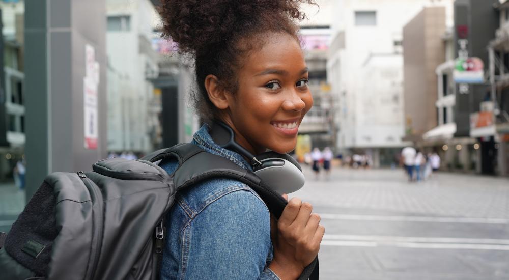 Student in a backpack on a city street