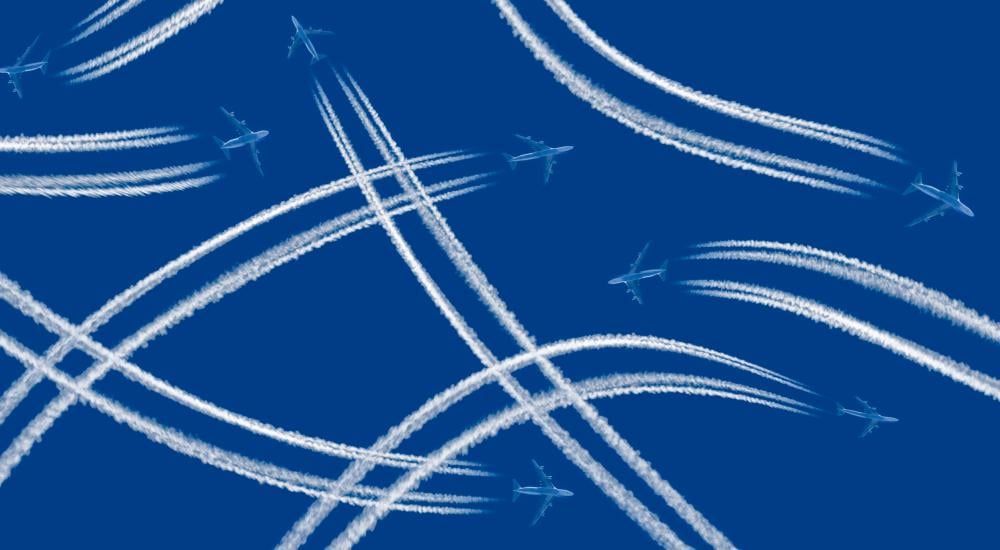 intersecting flight paths across blue sky