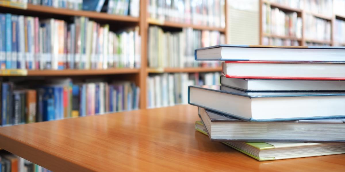 stack of books on a table in a library