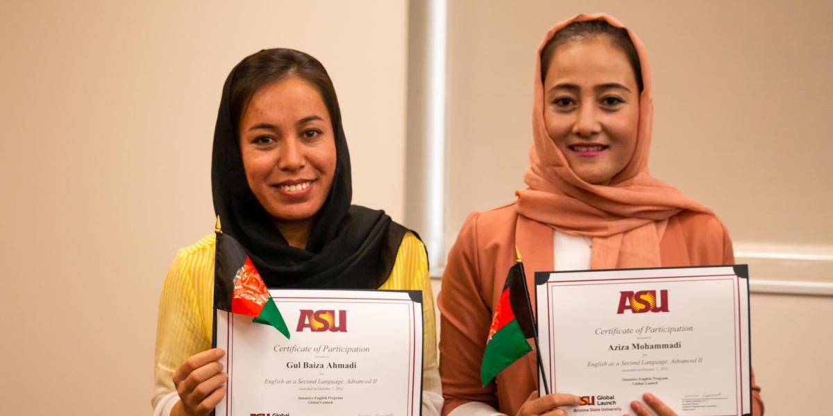 Two women hold certificates