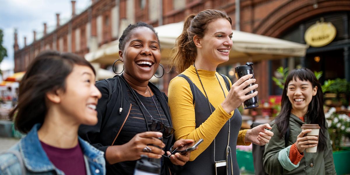 photo of four smiling young women walking