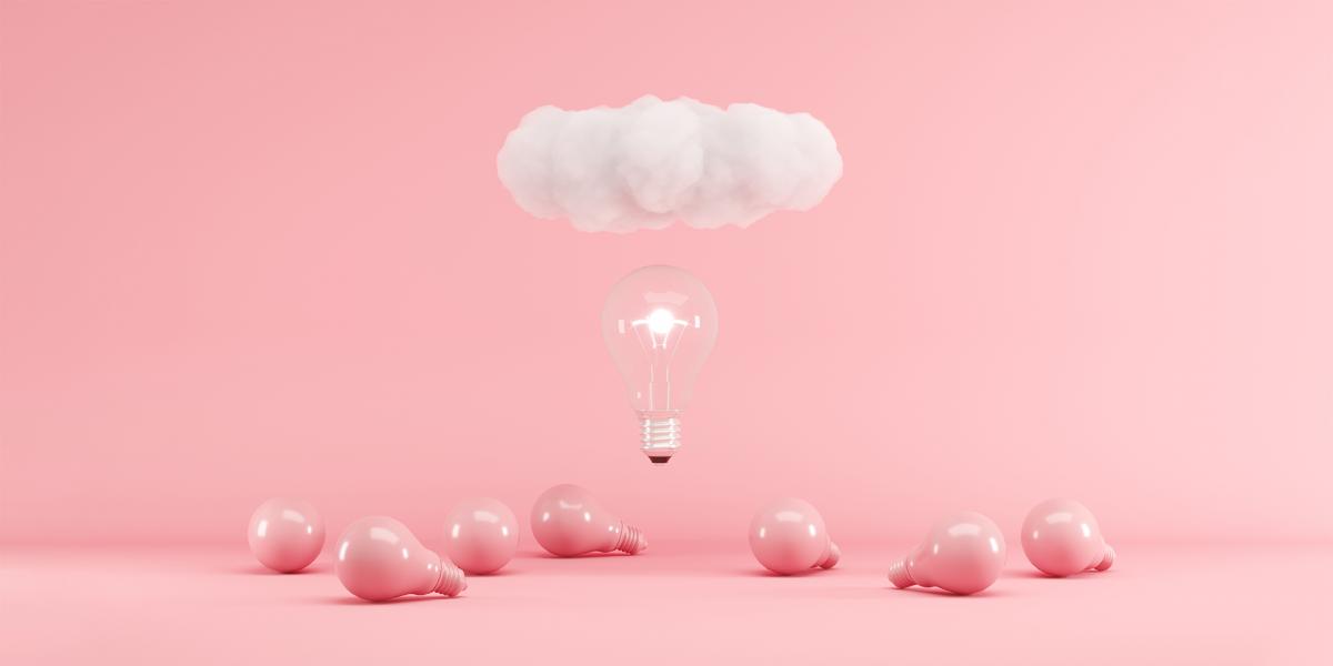 illuminated lightbulb and cloud floating above pink lightbulbs on pink ground