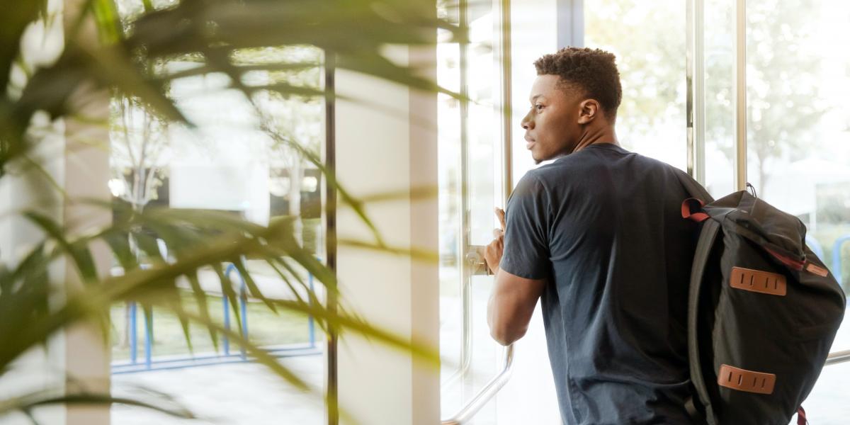 Photo of a student walking out of a building