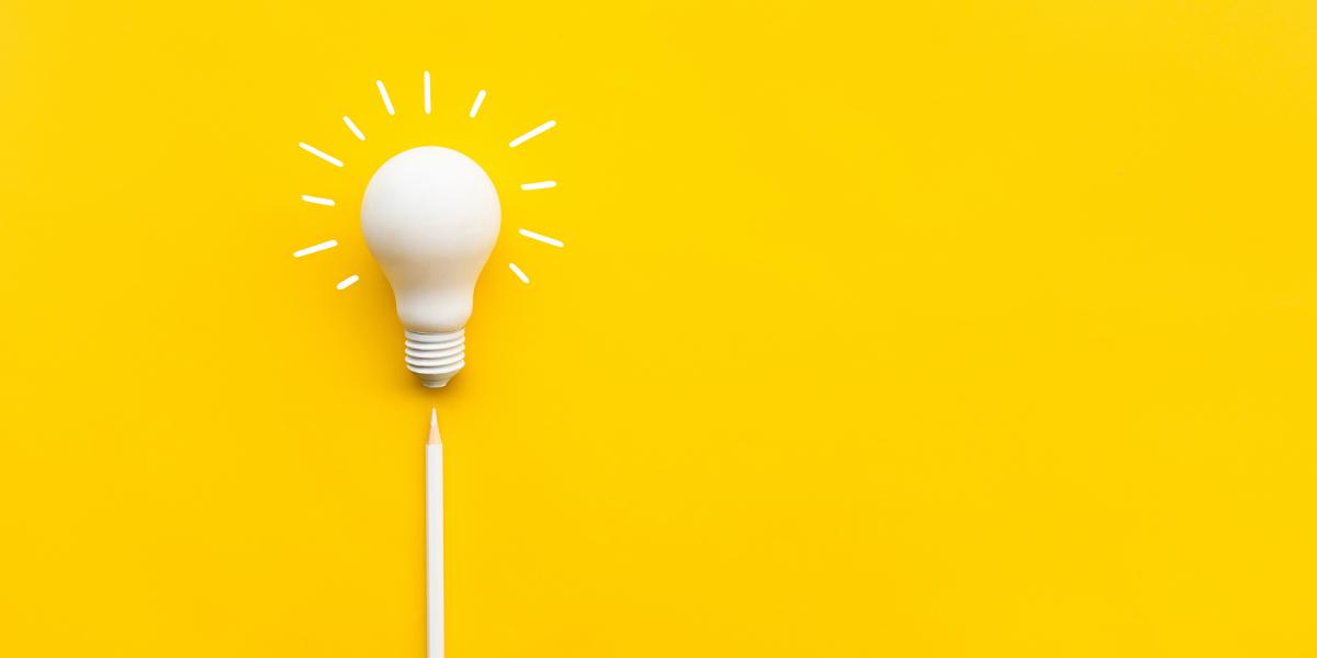 A white lightbulb on a yellow background