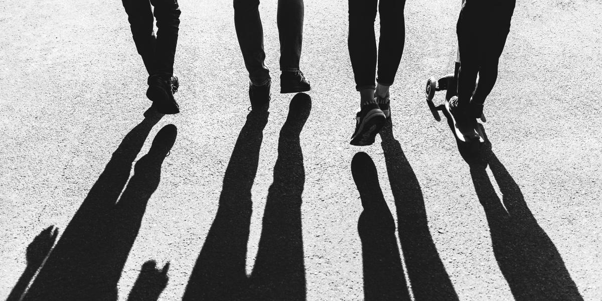 Shadows of four people walking