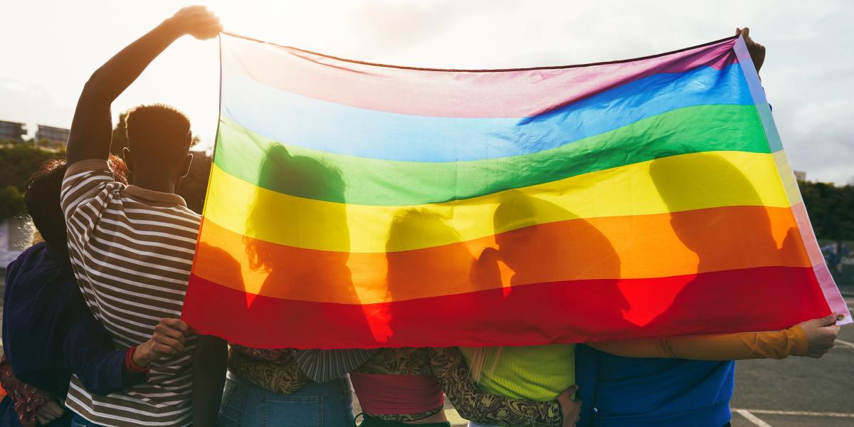 Photo of a group of students holding a pride flag.