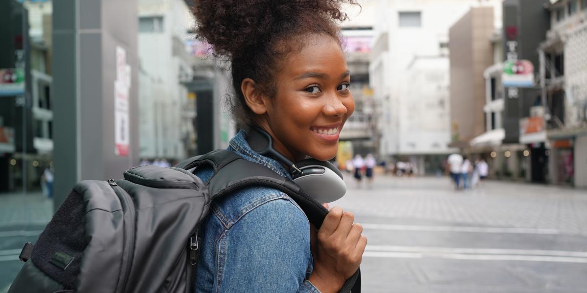 Student in a backpack on a city street