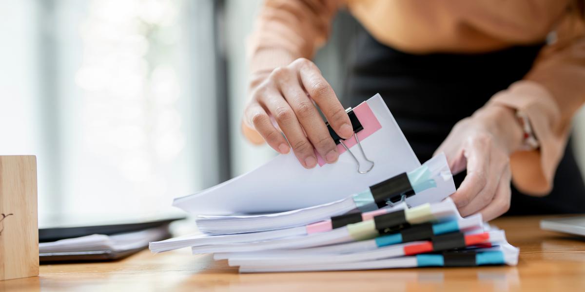 Desk with stack of paper files