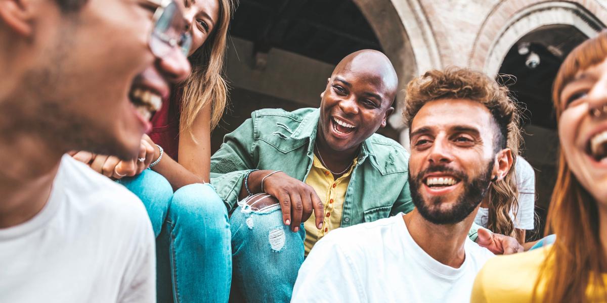 diverse group of young people sitting and laughing together