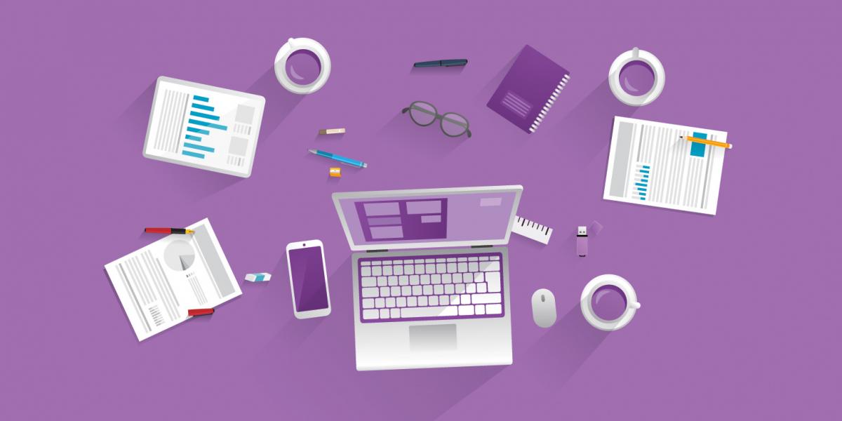 birds-eye view of desk with computer, papers, coffee cups