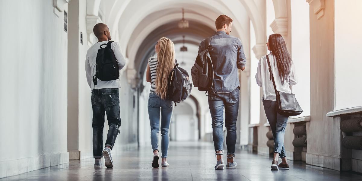 Four students walking down a hallway