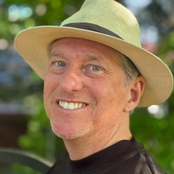 Man smiling wearing a hat with blue eyes