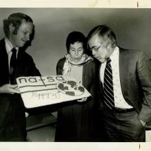 Photograph of someone blowing candles on a NAFSA cake