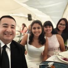 A group poses for a selfie at a wedding.