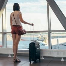 Student waiting at the airport with luggage