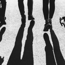 Shadows of four people walking