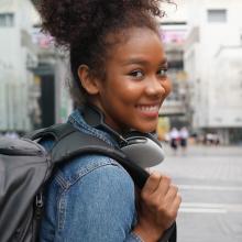 Student in a backpack on a city street