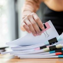 Desk with stack of paper files