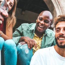 diverse group of young people sitting and laughing together