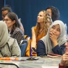 international professionals listen intently to symposium speakers